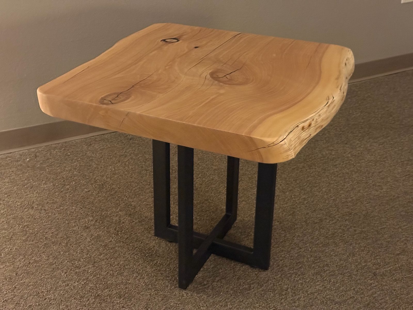 Alligator juniper live-edge side table on the studio floor