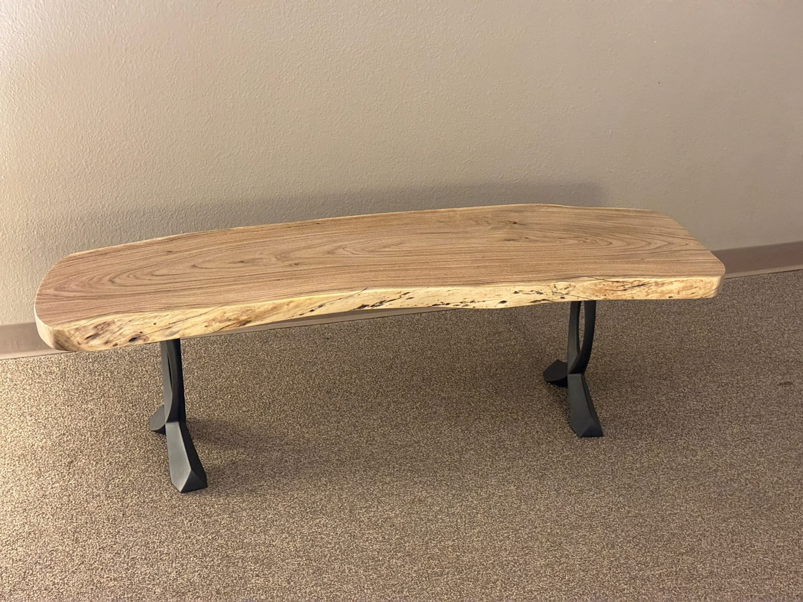 Mesquite live-edge bench on the studio floor