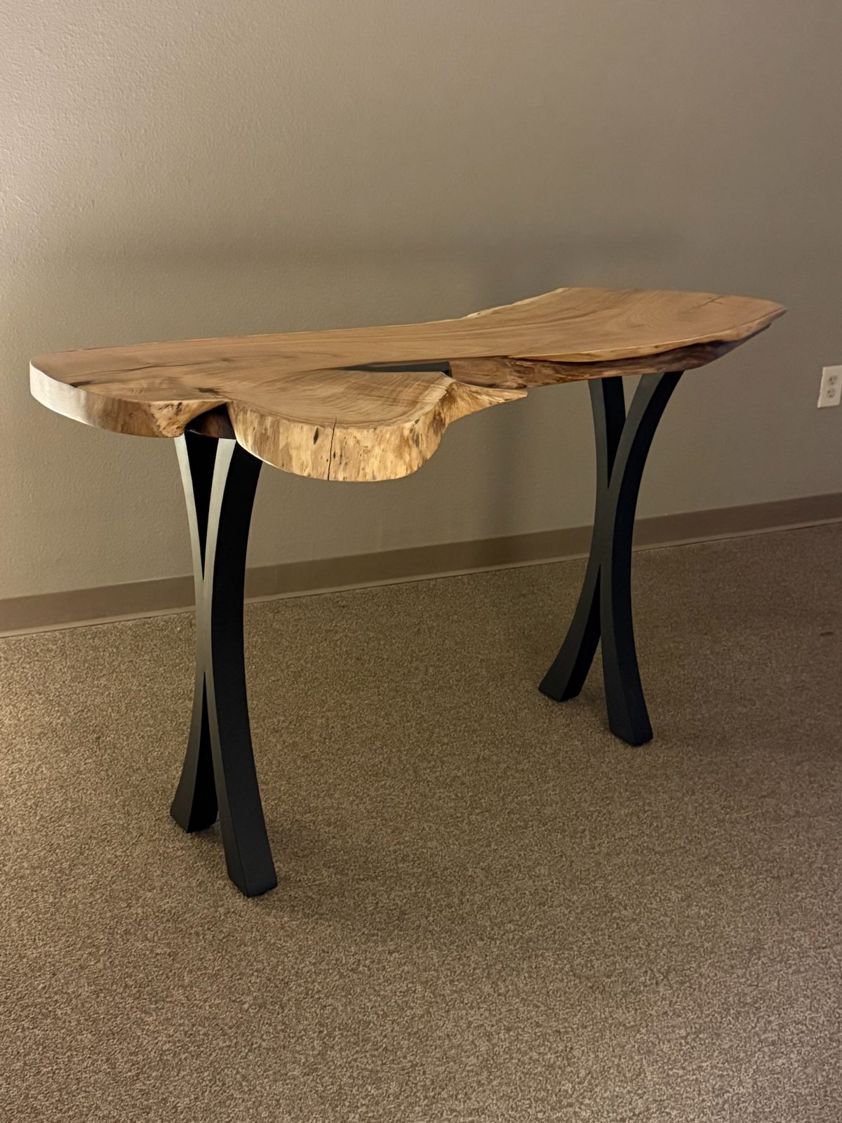 Mesquite live-edge console table on the studio floor